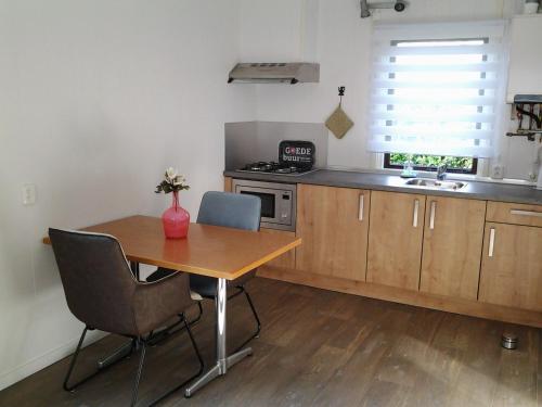 a kitchen with a wooden table and a sink at Bed & Breakfast Meinsma in Moddergat