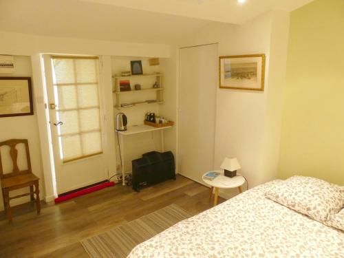 a bedroom with a bed and a chair and a window at Dépendance sainte Anne in Marseille