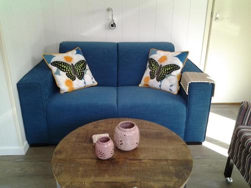 a blue couch with pillows and a coffee table at Bed & Breakfast Meinsma in Moddergat