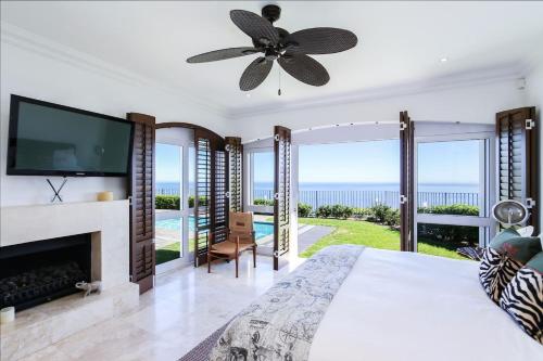 um quarto com uma cama grande, uma lareira e uma televisão em La Maison Hermes - Heated Saltwater Pool em Cidade do Cabo