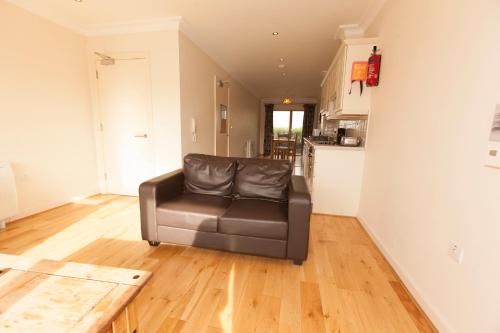 a living room with a leather chair and a kitchen at Assaroe Falls in Ballyshannon