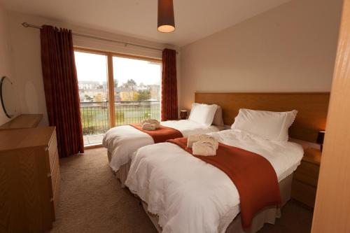 two beds in a hotel room with a window at Assaroe Falls in Ballyshannon