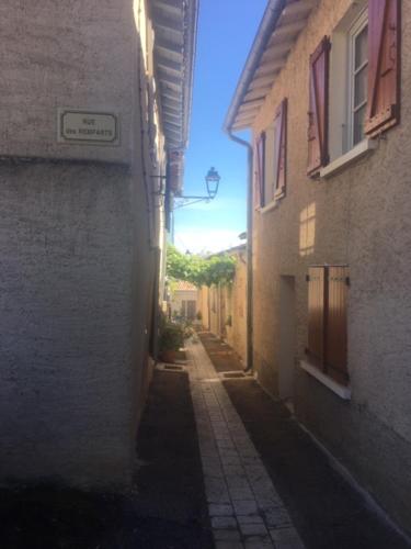 Une allée avec un bâtiment et une rue dans l'établissement La maison des remparts, à Lectoure