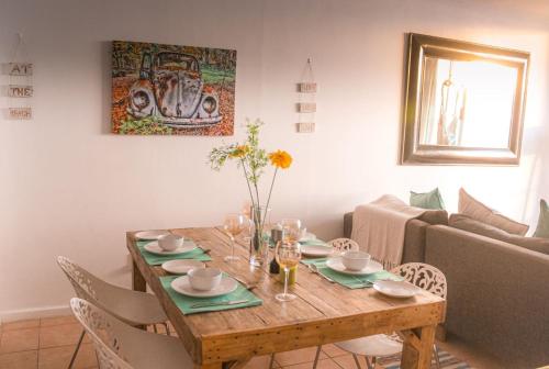a dining room table with chairs and a couch at Lagoon Beach Neptune Isle Cape Town in Cape Town