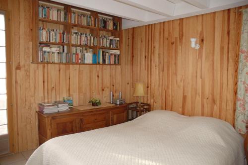 1 dormitorio con 1 cama y estantería con libros en L'Atelier de Maia, en Mormoiron