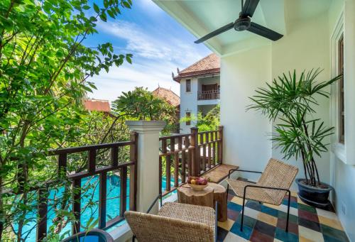 a balcony with chairs and a table at Rambutan Resort – Siem Reap in Siem Reap