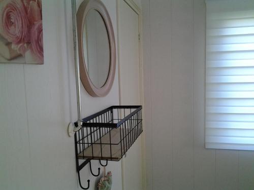 a bathroom with a mirror and a basket on the wall at Bed & Breakfast Meinsma in Moddergat