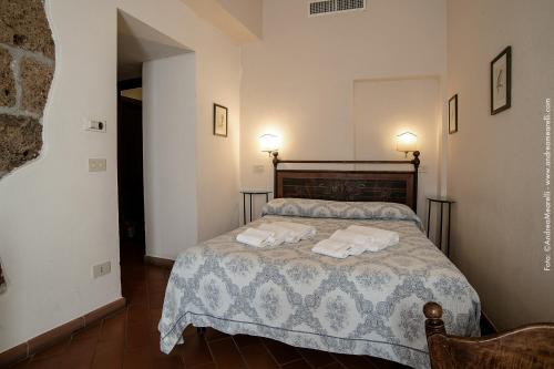 a bedroom with a bed with two towels on it at Hotel Scilla in Sovana