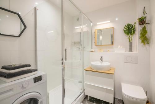 une salle de bain blanche avec une douche et un lavabo dans l'établissement Studio Confort O NICO-Dormiratoulouse Colomiers, à Colomiers