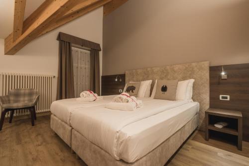a bedroom with a large bed with towels on it at X Alp Hotel in Pozza di Fassa