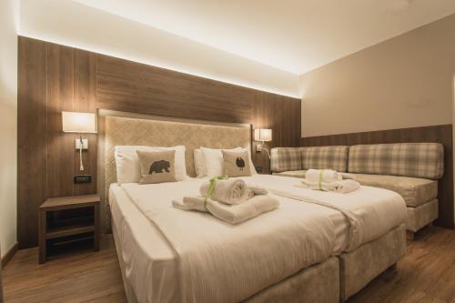 a bedroom with a large bed with towels on it at X Alp Hotel in Pozza di Fassa