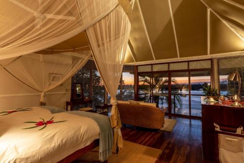 ein Schlafzimmer mit einem Himmelbett in der Unterkunft The River Club in Livingstone