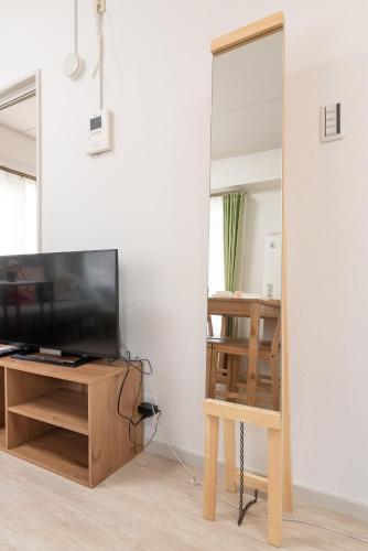 a mirror in a living room with a tv and a table at Uhome Iriya Apartment in Tokyo