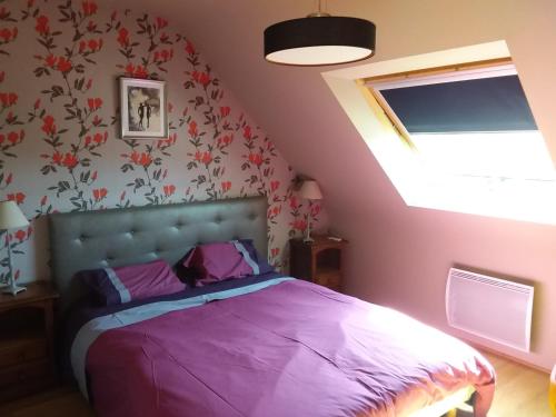 a bedroom with a purple bed and a window at Ker Kistin in Fouesnant