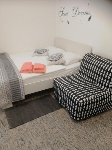 a bed and a couch and a chair in a room at Apartma ROK in Ankaran