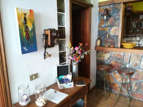 a room with a table with a vase of flowers on it at La Casita del acantilado in Puerto de la Madera