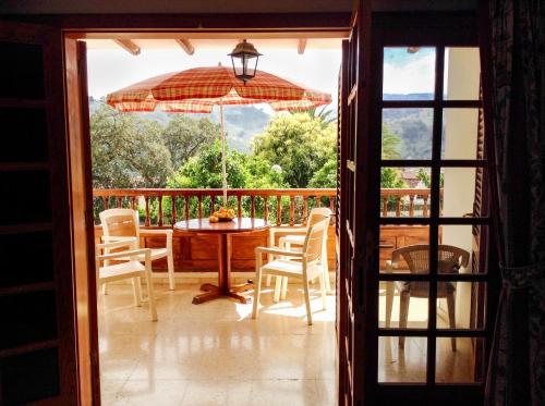 an open door to a patio with a table and an umbrella at Villa Santini in Teror