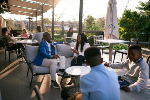 a group of people sitting in a restaurant at Seven Villa Hotel & Spa in Johannesburg