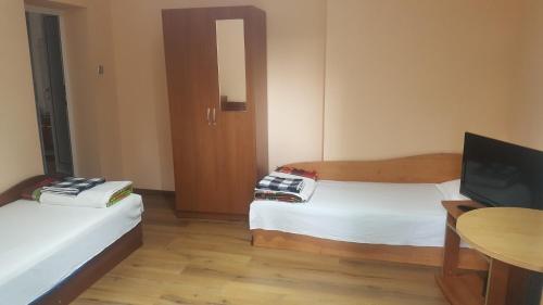 Cette chambre comprend 2 lits, une télévision et une table. dans l'établissement Guest House Zdravets, à Sapareva Banya