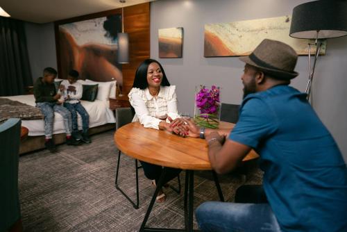a man and a woman sitting at a table in a hotel room at Seven Villa Hotel & Spa in Johannesburg
