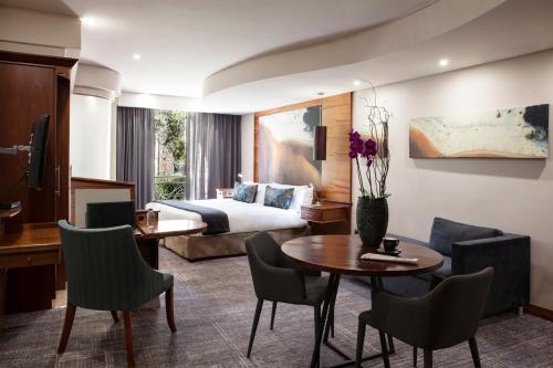 une chambre d'hôtel avec un lit, une table et des chaises dans l'établissement Seven Villa Hotel & Spa, à Johannesbourg