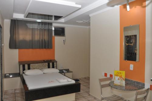 a room with a bed and a table in it at Hotel Sol Centro (Adults Only) in Goiânia