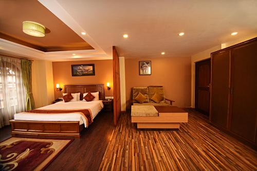 a hotel room with a bed and a chair at DOM Himalaya Hotel in Kathmandu