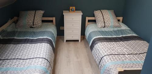 a bedroom with two twin beds and a dresser at Les terrasses in Malmedy