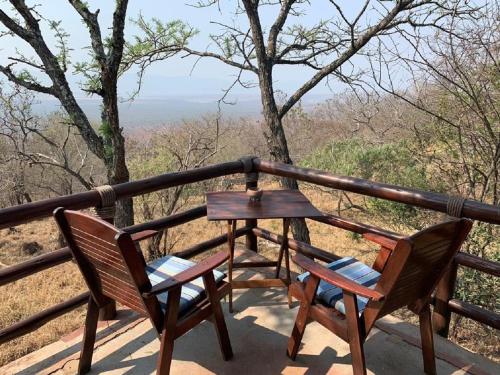 a table and chairs on a balcony with a view at Shayamoya Tiger Fishing and Game Lodge in Pongola Game Reserve