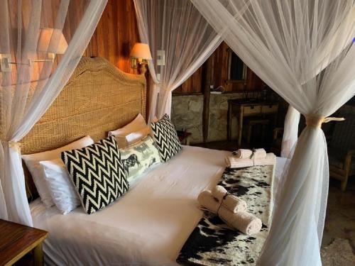 a bedroom with a white bed with a canopy at Shayamoya Tiger Fishing and Game Lodge in Pongola Game Reserve