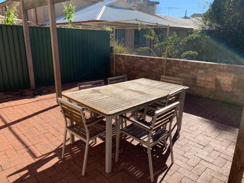 a wooden table and chairs on a patio at Cozy 3BR Townhouse in Liverpool CBD with parking in Liverpool