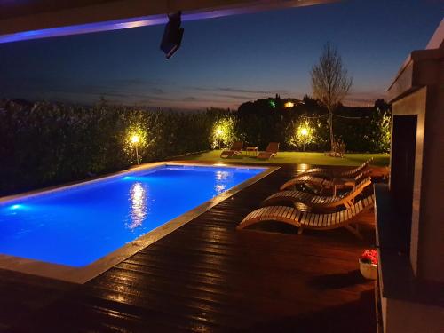 a swimming pool in a backyard at night at Villa Perlla in Split