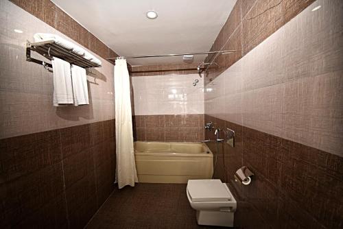 a bathroom with a toilet and a bath tub at DOM Himalaya Hotel in Kathmandu