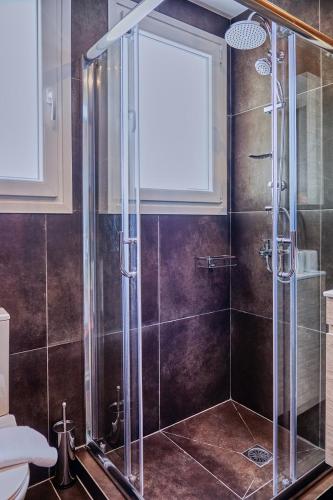 baño con ducha y puerta de cristal en Keramikos Comfortable Apartment #2 en Atenas