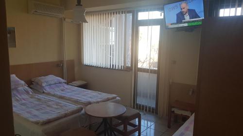 ブルガスにあるDvete Breziのベッド2台、テレビ、テーブルが備わる客室です。