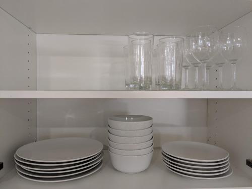 two stacks of plates and glasses on a shelf in a kitchen at Spacious basement one bedroom apartment, WiFi. in Montreal