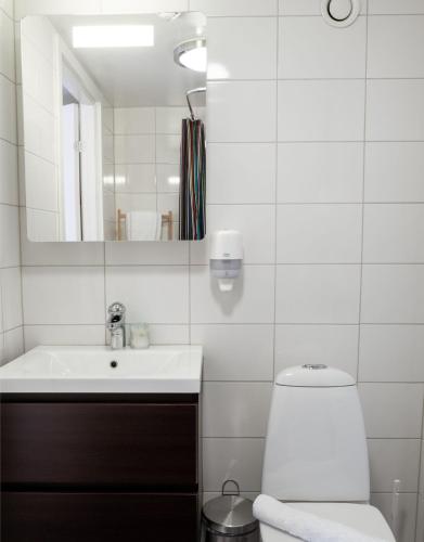 a bathroom with a sink and a toilet and a mirror at EttSmart Hotell in Sollentuna