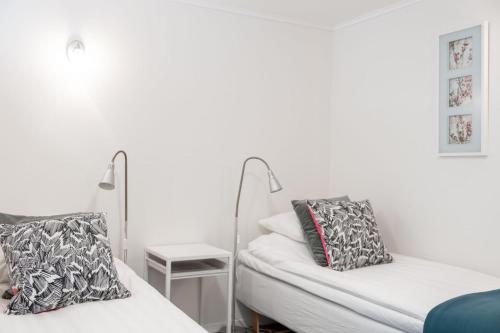 a white room with two beds and a table at EttSmart Hotell in Sollentuna