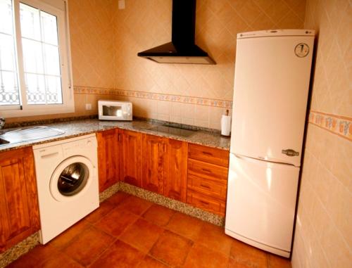 uma cozinha com um frigorífico branco e uma máquina de lavar roupa em Casa Rural El Limonero em Los Naveros