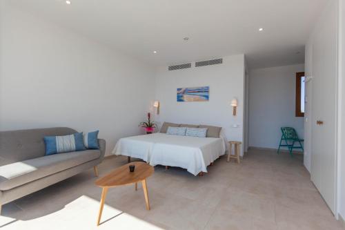 a living room with a bed and a couch at Apartamentos Villa Primera in Cala Figuera