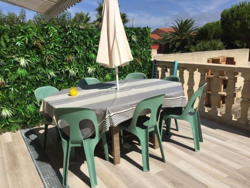 une table et des chaises avec un parasol sur une terrasse dans l'établissement Mas Catalan, à Torreilles