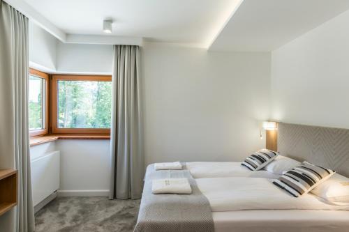 a bedroom with two beds and a window at Royal Hill Residence in Zakopane