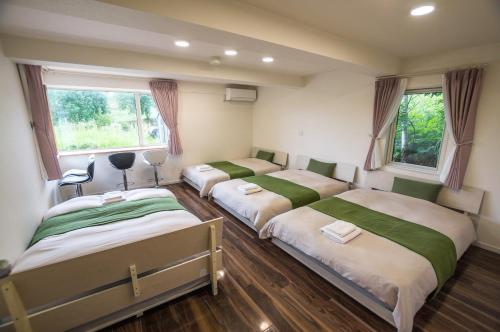 a group of four beds in a room at Ritz Garden Niji in Biei