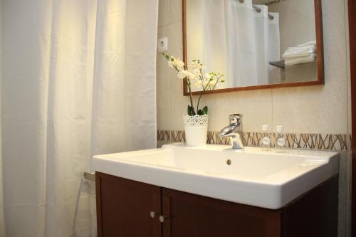 uma casa de banho com um lavatório branco e um espelho. em Sleeping to the sound of Fado em Lisboa