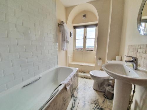 a bathroom with a tub and a sink and a toilet at The Old Lodge in Stroud