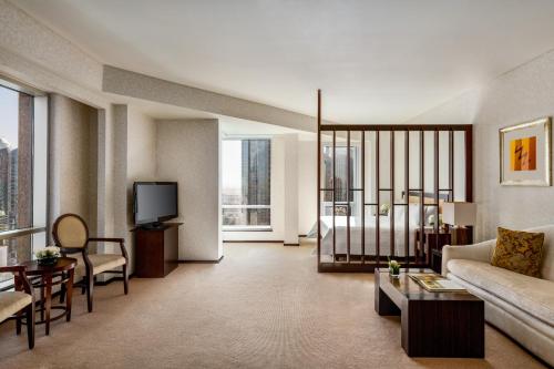 a living room with a couch and a tv at Shangri-La Apartments in Dubai