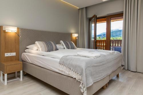 1 dormitorio con 1 cama grande y balcón en Royal Hill Residence, en Zakopane