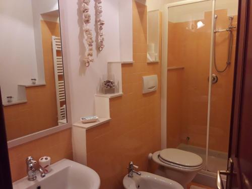 Un baño con inodoro, lavabo y ducha. en Villa Capitolo, en Monopoli