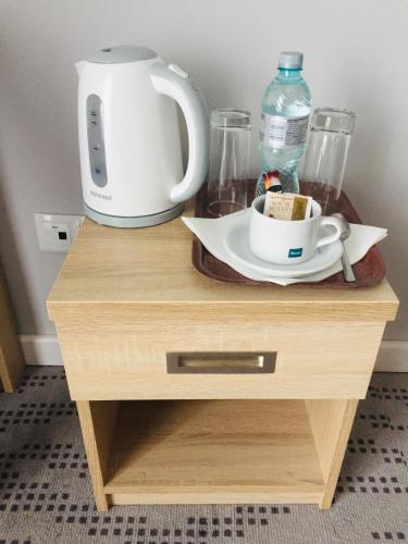 a table with a coffee maker and a cup on it at Nova Stodola in Kłomnice