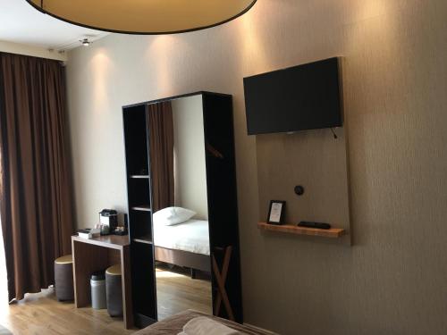 a hotel room with a large mirror and a television at Hotel Mosaic City Centre in Amsterdam